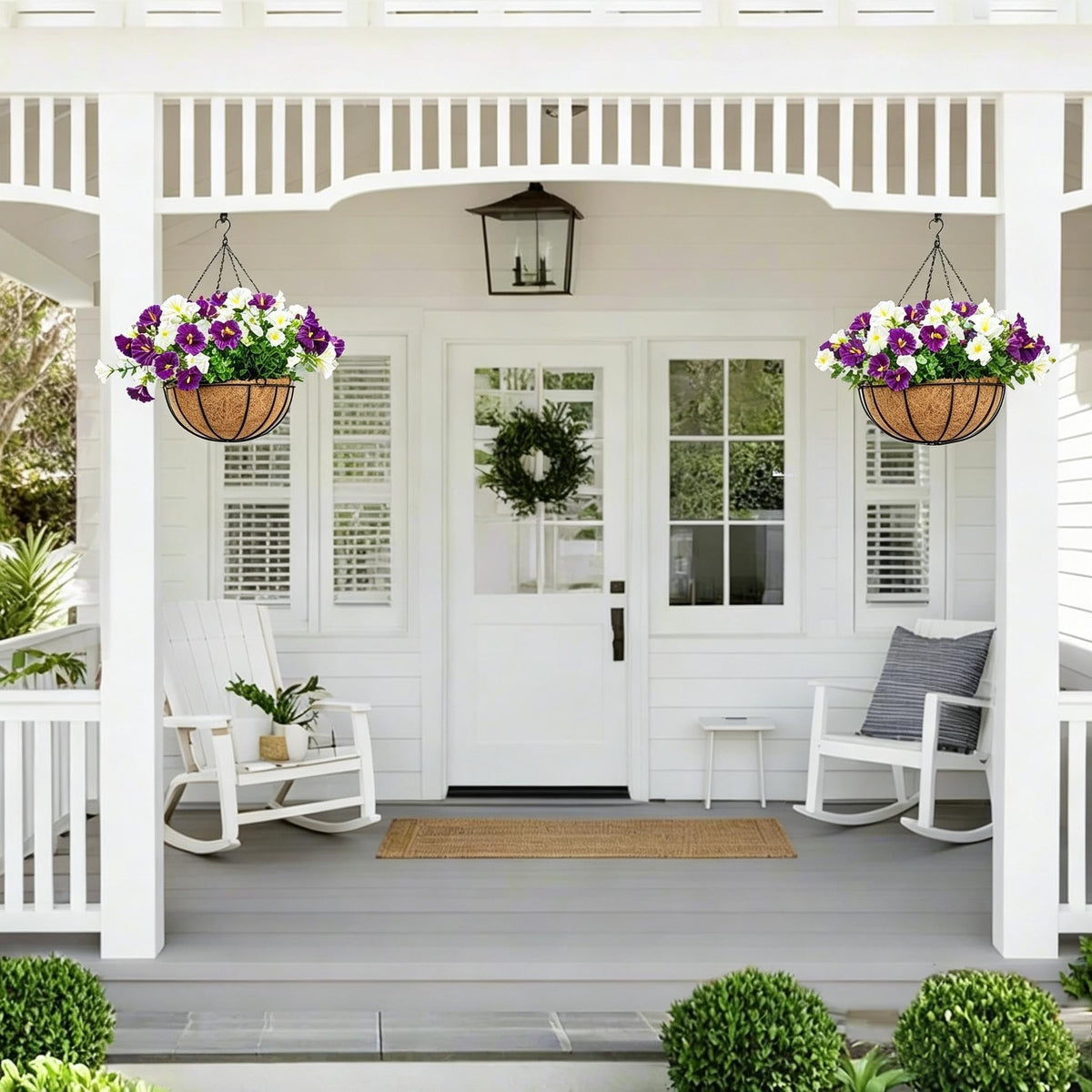 Pair of white and purple artificial hanging flower baskets decorating a front porch