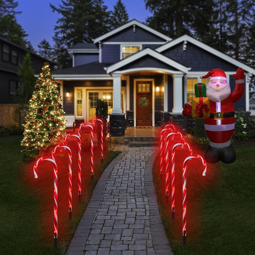 Red candy cane Christmas pathway lights lining a front yard walkway at night
