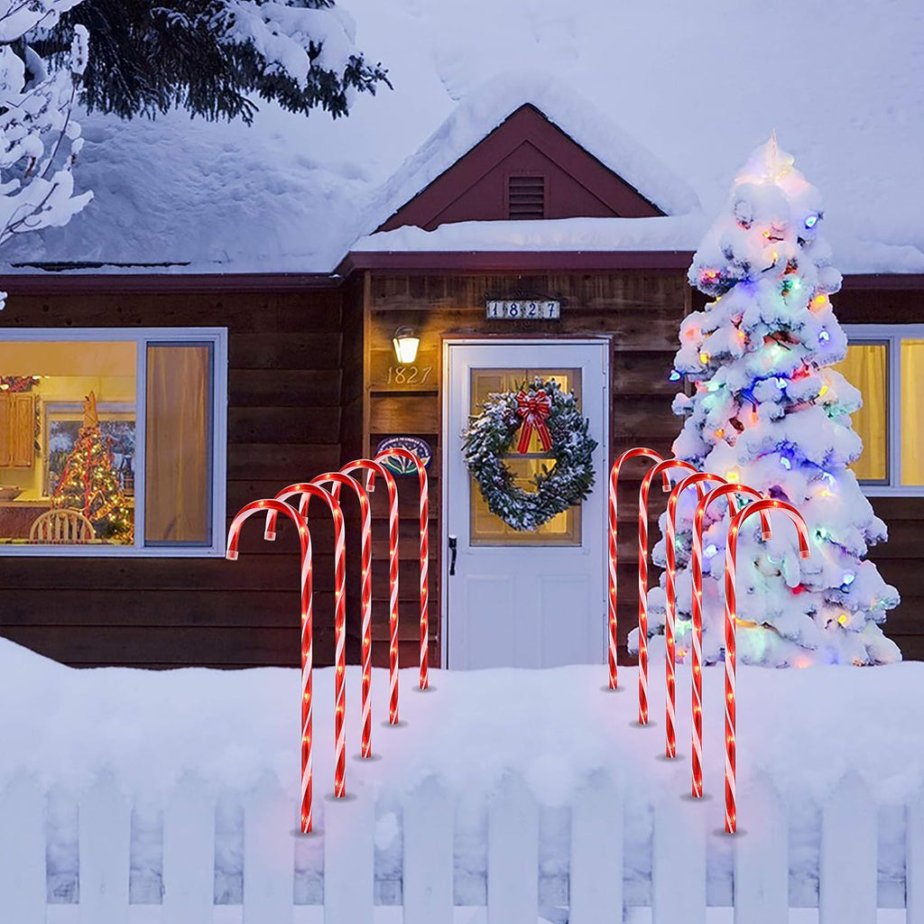 Outdoor candy cane lights decorating a snowy front yard for Christmas