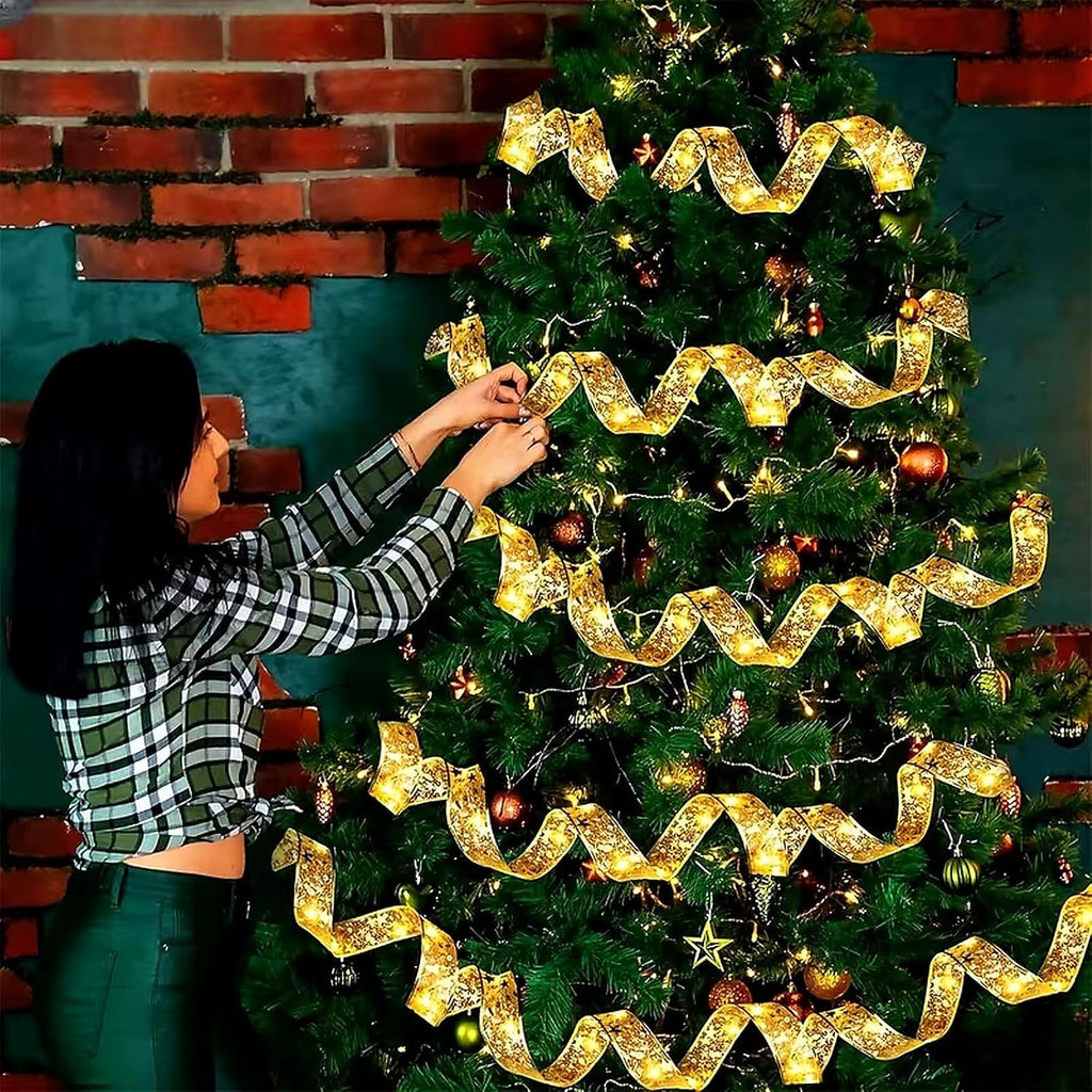 Woman decorating a Christmas tree with flexible gold ribbon fairy lights